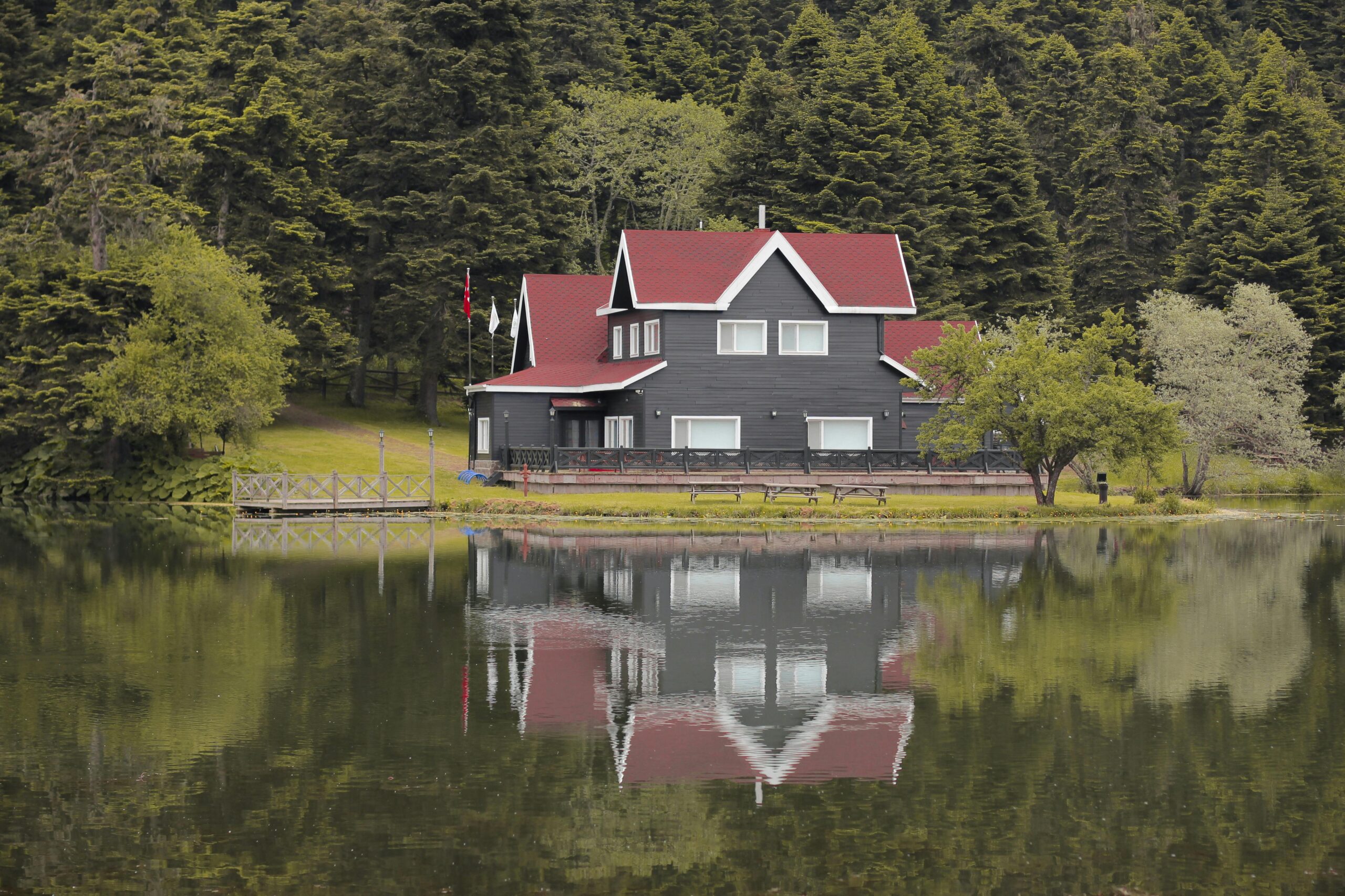 Lakeside cabin with red roof and reflection