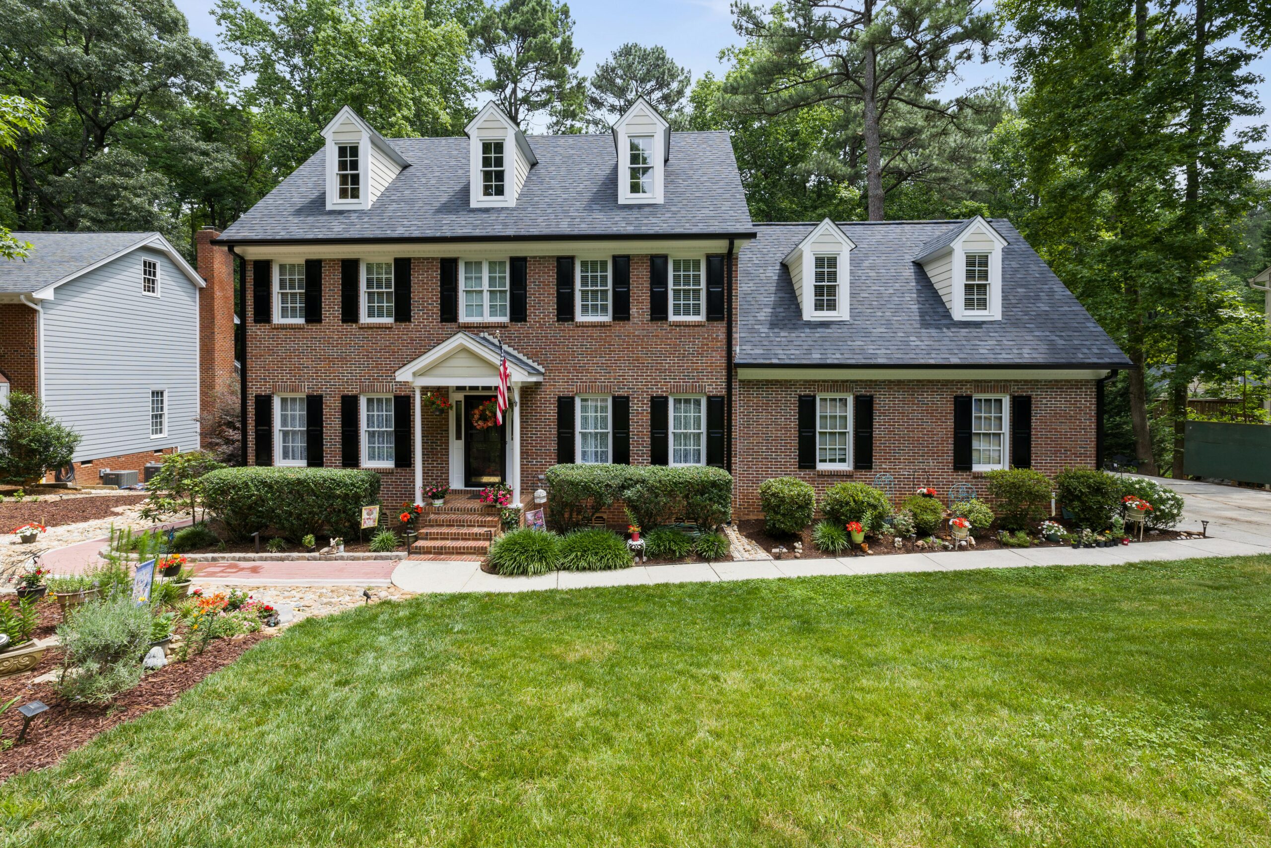 Brick colonial house with dormers and lawn