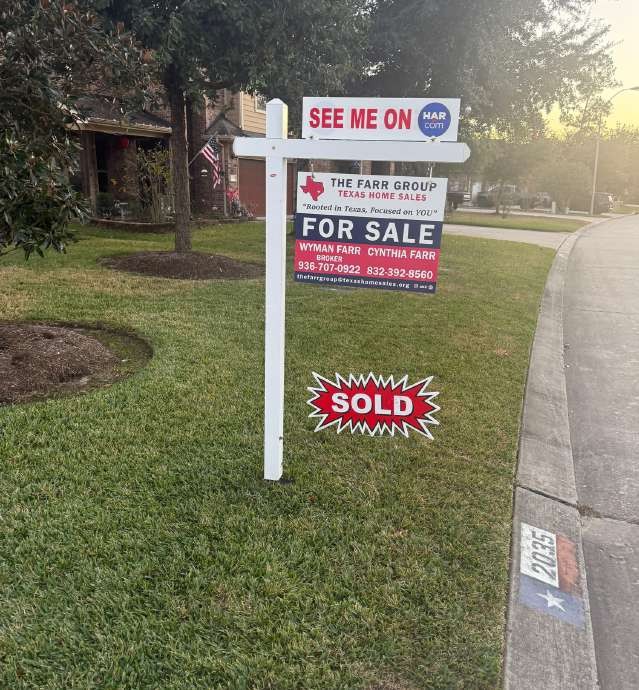 Yard real estate sign marked SOLD