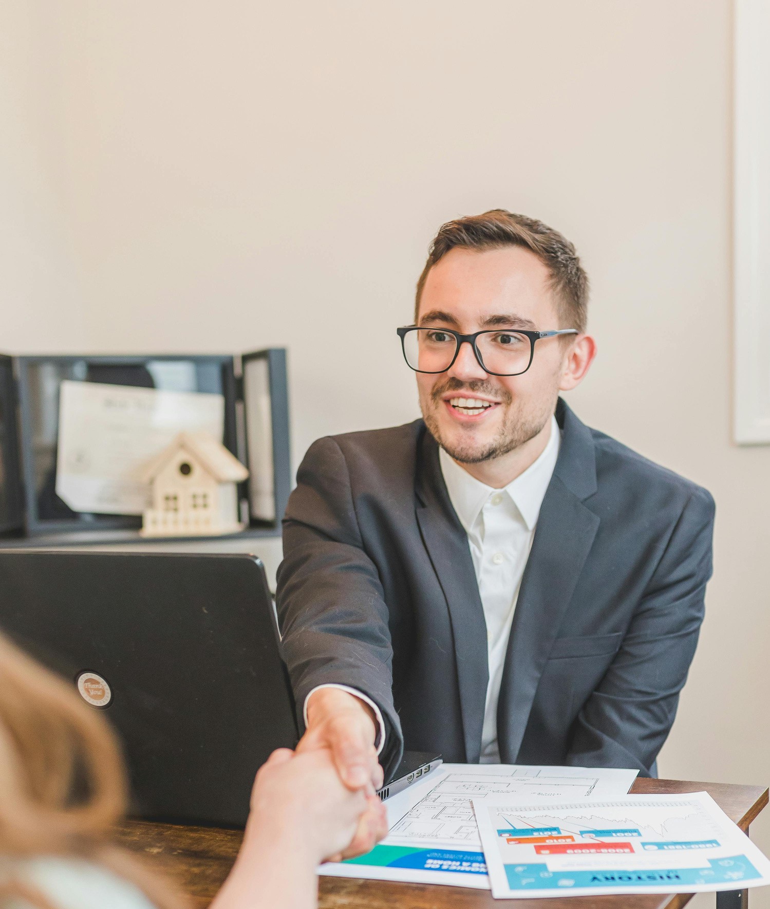 Smiling businessman shaking hands over paperwork