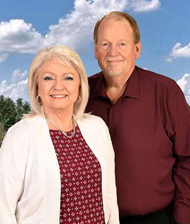 Smiling older couple portrait with cloudy sky