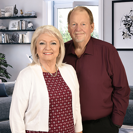 Smiling senior couple standing in living room