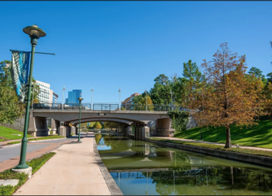 Urban canal with bridge, walkway, trees